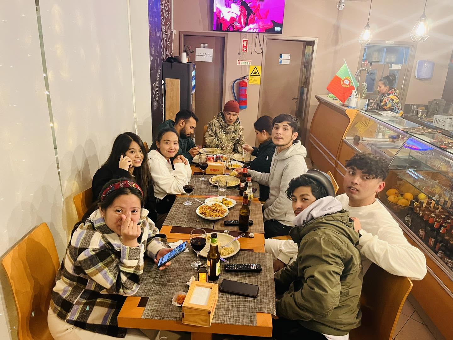 A large group of friends sharing dinner along the long table in the Cozy Restaurant dining room